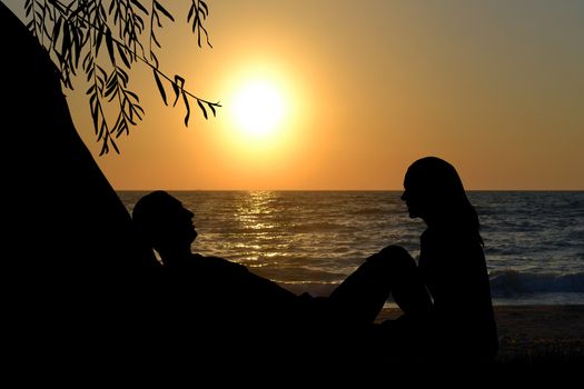 Romantic couple near the sea at sunrise