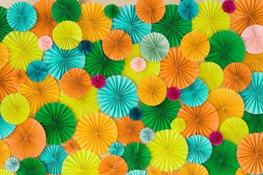 Colorful celebration background wall with multicolored paper circles of yellow, orange, green and blue colors