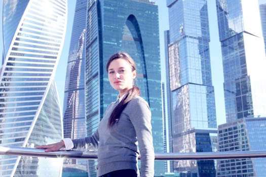 Young beautiful businesswoman outdoors at skyscraper background