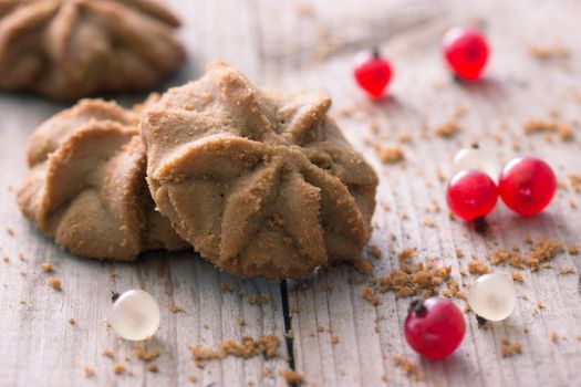 cookies with red berries on wooden table