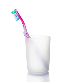 One toothbrushe in a glass on white background