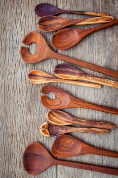 Wooden cooking utensils border wooden spoons, spatula , wooden fork  on background of aged weathered vintage wood with a rough rustic texture.