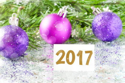 Fir tree branch and christmas toys bauble and snow flares confetti with 2017 text lettering. 2017 new year concept