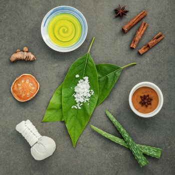 Avocados leaves with nature spa ingredients turmeric,herbal compress ball,dried indian bael ,cinnamon powder ,cinnamon sticks ,aromatic oil ,star anise,aloe vera and sea salt on concrete background.