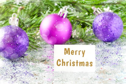 Fir tree branch and christmas toys bauble and snow flares confetti with Merry christmas text lettering. Merry christmas concept