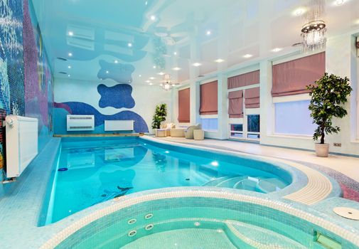 Swimming pool interior design with blue mosaic and plants