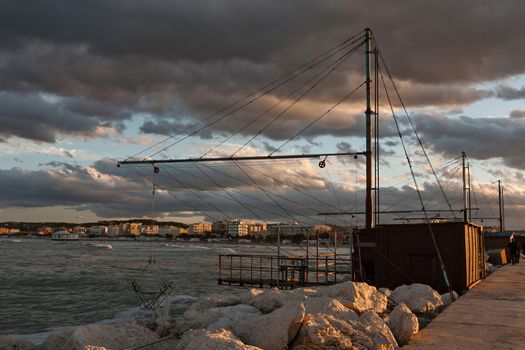 The fishnets in the port at sunset under a cloudy sky