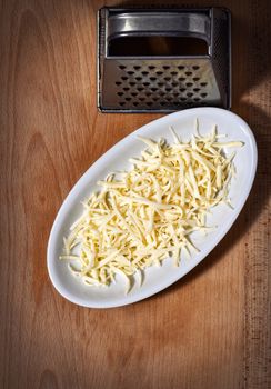 grater and grated hard cheese on a plate