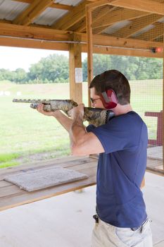Young man sharpening his skills  with pump action type weapon at local rifle range