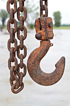 Close up of old rusty metal chain and hook at construction site, old chain and hook, rusty chain and hook