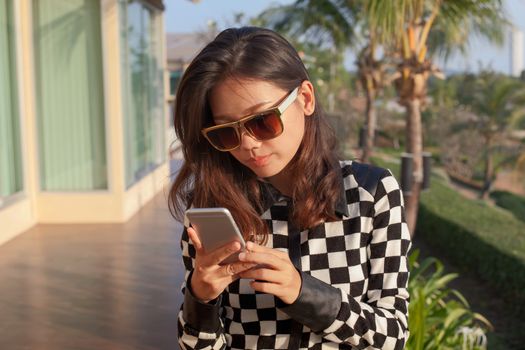 portrait oy young woman reading message on mobile phone use for modern digital connecting technology 