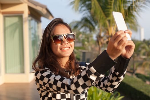 portrait of young beautiful woman wearing sun glasses take a photo ,selfie by mobile phone use for modern digital life and people activities 