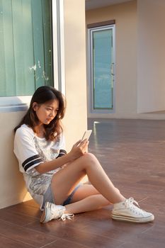 portrait of teen woman with serious face looking and reading message on mobile phone by unhappy face use for people and life problem