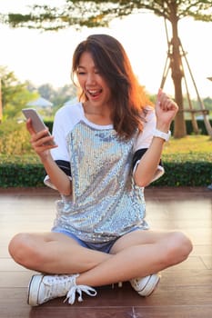 portrait of young woman watching to mobile phone screen with surprising and happiness face 