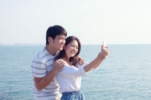 portrait of young man and woman selfie ,self portrait by mobile phone in relaxing emotion sea beach destination use for people in modern life style