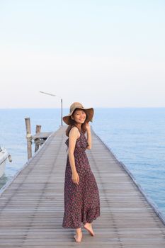 portrait beautiful woman wearing wide straw hat and long dress walking on wood bridge piers use for people relaxing and activities on holiday vacation 