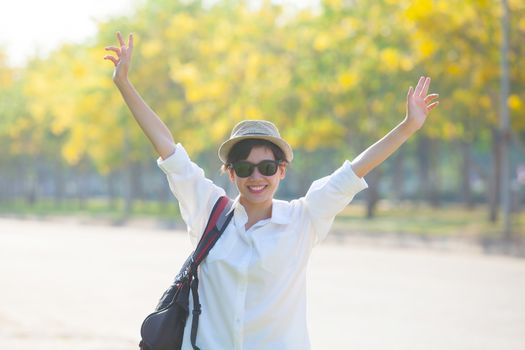 young beautiful woman wearing white shirts ,straw hat and sun glasses rising hand victory shape and toothy smiling use for modern and people lifestyle  feeling free 