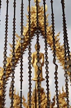 View through the crystal bead behind a curtain is buddha statue and blue sky