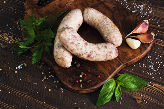 Raw sausages with garlic and parsley on the cutting board