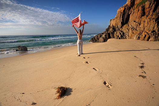 Smell the sea and feel the sky, let your soul and spirit fly.   A woman walks with joy along the beach, leaving footprints in the sand.