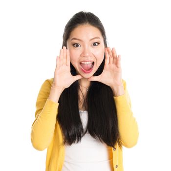 Portrait of Asian girl, shouting and looking at camera, standing isolated on white background.