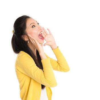 Portrait of Asian girl, shouting and looking up, standing isolated on white background.