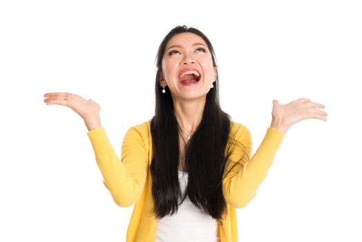 Surprised Asian woman mouth open wide, shouting and looking up, standing isolated on white background.