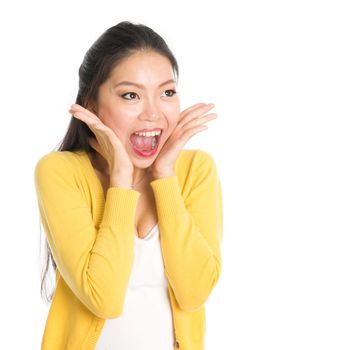 Shocked Asian woman mouth open wide, shouting and looking at side, standing isolated on white background.