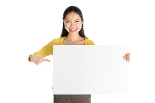 Portrait of casual Asian woman hand holding blank white paper card and pointing on it, isolated on white background.