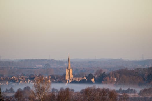 Mid Winter Foggy Sunrise over Lechlade Church in Gloucstershire, England.