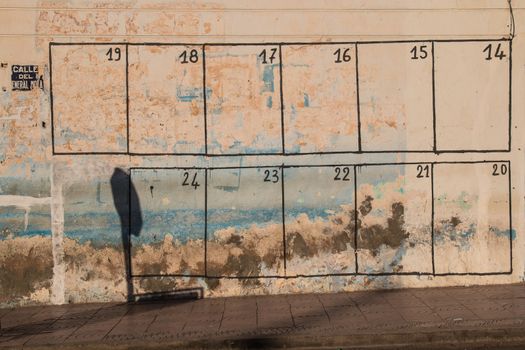 In every city in Morocco is painted on the wall a calendar of the events, which will happen in the city. This one is on an old peeled off wall in a city Sidi Ifni.