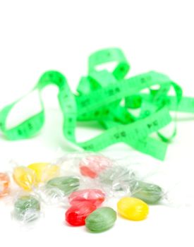 picture of a the colored fruit taste candies. and tape measure .sweet food concept