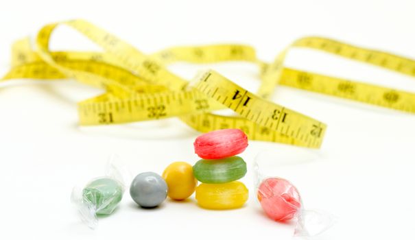 picture of a the colored fruit taste candies. and tape measure .sweet food concept