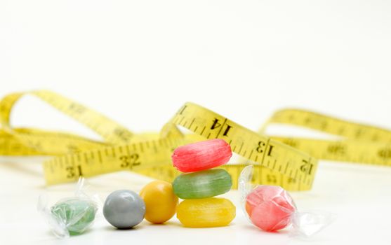picture of a the colored fruit taste candies. and tape measure .sweet food concept