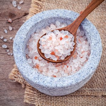 Himalayan pink salt in mortar on hemp sack background. Himalayan salt commonly used in cooking and for bath products such as bath salts