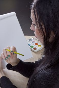 Young girl artist drawing pencils and paints