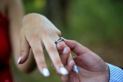 Engagement ring on womans hand held by her friend , picture of a