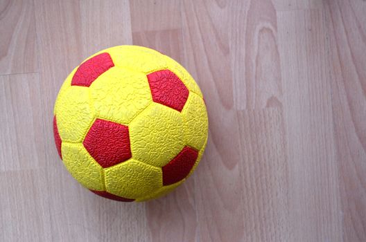 picture of a Red and yellow Soccer Ball on a wooden background