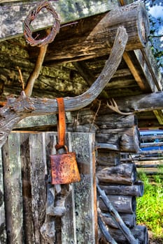 An old bell in front of a wooden house