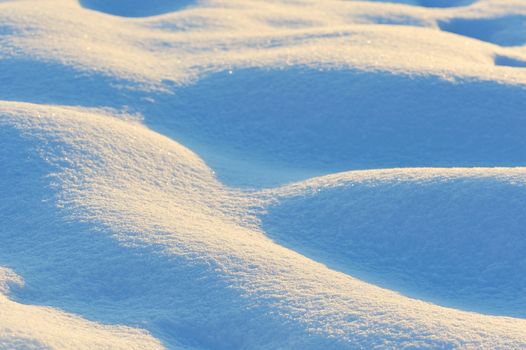 wavy fresh snow with blue tint and sunrise