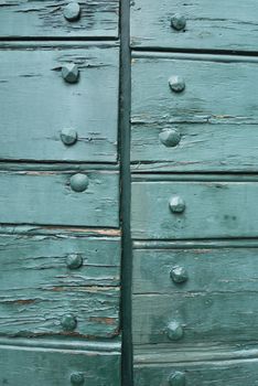 Closed Wood gate doors painted in green and  exposed bolts.
