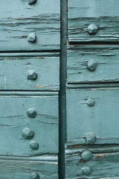 Closed Wood gate doors painted in green and  exposed bolts.