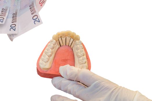 Denture and euro bills, a focus on the artificial teeth. Symbol of high dentures cost.