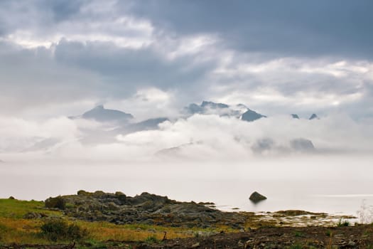 Coast of  Norway sea in clouds of fog. Cloudy Nordic day on Lofoten islands