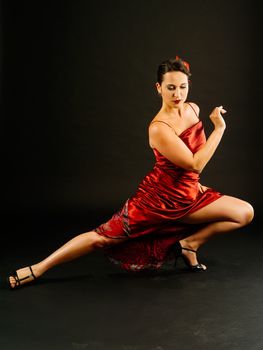 Photo of a young beautiful woman performing tango moves.