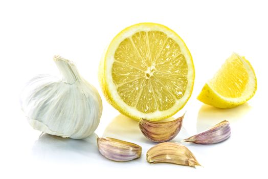 Garlic bulb and clove with sliced lemon isolated on a white background