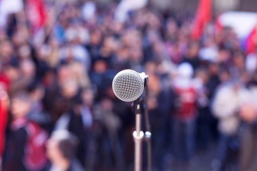 Street protest. Political rally. Microphone in focus against blurred crowd. 