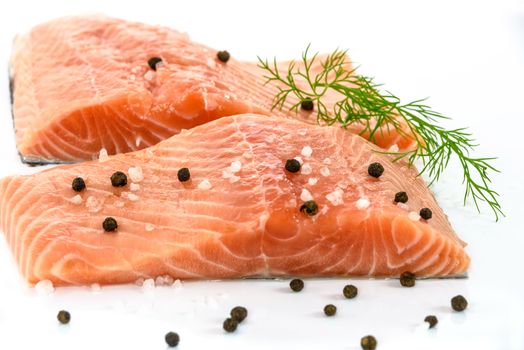 Patches of fresh salmon marinated with sea salt, pepper and dill isolated on a white background