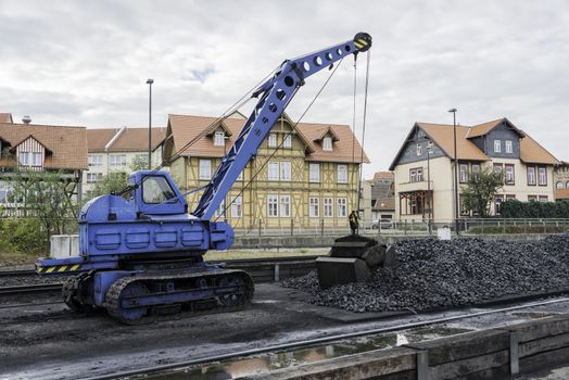 old blue crane with crawler with bucket to load coal into the steam locomotive