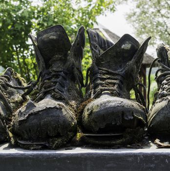 row of old leather worn out shoes in garden